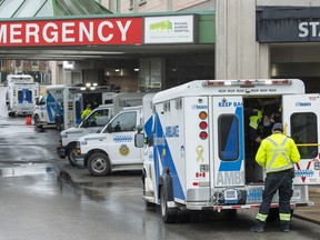 Paramedics and ambulances spill out of the Emergency ramp at a Toronto hospital on Monday, April 12, 2021.