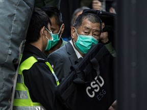 This photo taken on February 1, 2021 shows Hong Kong media tycoon Jimmy Lai being escorted into a Hong Kong Correctional Services van outside the Court of Final Appeal after being ordered to remain in jail while judges consider his fresh bail application. Lai was among three democracy campaigners convicted on December 9, 2021 for taking part in a banned Tiananmen vigil as the prosecution of multiple activists came to a conclusion.