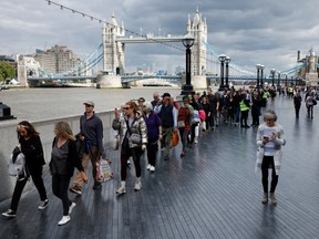 People walk in line along The Queens Walk near Tower Bridge as they march toward the public viewing of Queen Elizabeth II lying in state at Westminster Hall on September 15, 2022 in London, England.