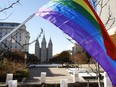 A pride flag flies in front of the Salt Lake Temple during a protest in Salt Lake City, Utah, in 2015.