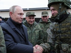 Russian President Vladimir Putin with Defence Minister Sergei Shoigu standing next to him, speaks to a mobilized reservist in October. Shoigu's son-in-law refused to tell a reporter whether he would fight in Ukraine.