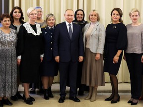 Russia's President Vladimir Putin poses for a photo with mothers of Russian soldiers fighting in the Russia-Ukraine conflict, November 25, 2022.