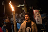 A Uyghur man who immigrated to Canada in 2007 with his parents holds a homemade torch during a protest against the Beijing Winter Olympics outside the Chinese consulate in Vancouver in February 2022. THE CANADIAN PRESS/Darryl Dyck