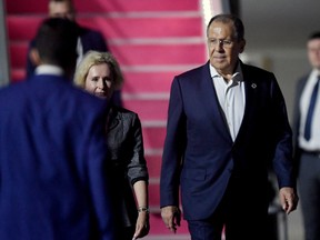 Russia's Foreign Minister Sergey Lavrov (R) arrives to attend the G20 Summit at Ngurah Rai International airport at Tuban, Badung regency on Indonesia's resort island of Bali, on November 13, 2022. (Photo by SONNY TUMBELAKA / AFP)