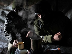 A member of the 68th Independent Jager Brigade of the Ukrainian Army prepares hot water for coffee in the kitchen area in a dug out field position near the frontline in the Southern Donbas region in Ukraine, November 29, 2022.