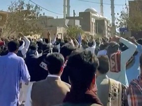 This image grab from a UGC video made available on October 14, 2022, shows Iranian protesters chanting slogans as they march in a street in the southeastern city of Zahedan. - Cities across Iran have seen protests since 22-year-old Iranian woman Mahsa Amini died on September 16 after her arrest by the morality police in Tehran for allegedly failing to observe the Islamic republic's strict dress code for women.