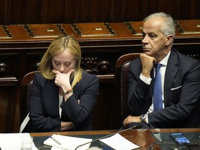 FILE - Italian Premier Giorgia Meloni, left, with Interior Minister Matteo Piantedosi at the lower Chamber on Oct. 25, 2022. Italy's new interior minister on Wednesday, Nov. 2, 2022, defended a government decree banning rave parties against criticism it could be used to clamp down on sit-ins and other forms of protest, while taking no action against a march by thousands of fascist sympathisers to the crypt of Italy's slain Fascist dictator.