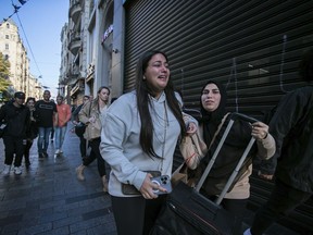 People leave the area after an explosion on Istanbul's popular pedestrian Istiklal Avenue Sunday, Istanbul, Sunday, Nov. 13, 2022. A bomb exploded on a major pedestrian avenue in the heart of Istanbul on Sunday, killing a handful of people, wounding dozens and sending people fleeing as flames rose.