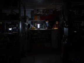Camping lights and candles illuminate a shop during a power outage in downtown Kyiv, Ukraine, Tuesday, Nov. 8, 2022.