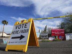 A voting sign points voters in the right direction to drop off ballots in Phoenix, Monday, Nov. 7, 2022.