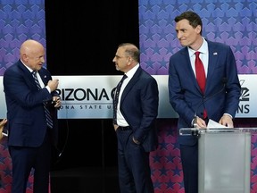 Arizona Democratic Sen. Mark Kelly, left, talks with Libertarian candidate Marc Victor, middle, and Republican candidate Blake Masters, right, prior to a televised debate in Phoenix, Thursday, Oct. 6, 2022.