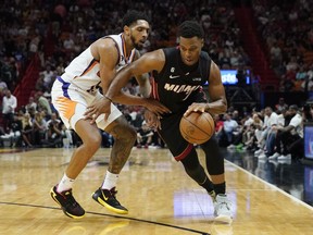 Miami Heat guard Kyle Lowry (7) dribbles around Phoenix Suns guard Cameron Payne (15) during the first half of an NBA basketball game Monday, Nov. 14, 2022, in Miami.