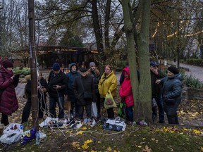 Residents plug in mobile phones and power banks at a charging point in downtown Kherson, southern Ukraine, Sunday, Nov. 20, 2022. Russian forces fired tank shells, rockets and other artillery on the city of Kherson, which was recently liberated from Ukrainian forces.