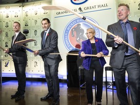 Daniel Sedin, left to right, Roberto Luongo, Herb Carnegie's daughter Bernice Carnegie, and Daniel Alfredsson pose with sticks during a ceremony at the&ampnbsp; Hockey Hall of Fame in Toronto, Friday, Nov. 11, 2022.