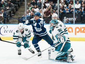 Toronto Maple Leafs' William Nylander (centre) reaches for the puck in front of San Jose Sharks' Matt Benning (left) and Sharks goaltender Aaron Dell during second period NHL hockey action in Toronto, on Wednesday, November 30, 2022.THE CANADIAN PRESS/Chris Young