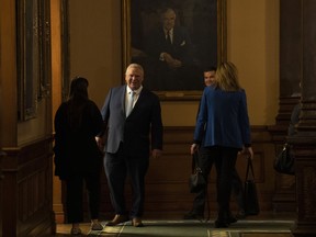 Ontario Premier Doug Ford talks to colleagues at the Queen's Park Legislature, in Toronto, Monday, Nov. 14, 2022.&ampnbsp;Ontario auditor general says the Progressive Conservative government spent about $13.75 million on ads she believes are partisan.