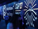 Conference participants walk through an illuminated tunnel at the UNFCCC COP27 climate conference on November 8, 2022 in Sharm El Sheikh, Egypt.