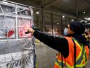 A FedEx employee scans a shipment containing 255,600 doses of the Moderna COVID-19 vaccine at Pearson International Airport in Toronto on March 24, 2021.
