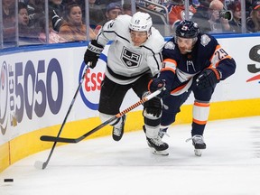 Los Angeles Kings' Trevor Moore (12) and Edmonton Oilers' Leon Draisaitl (29) battle for the puck during first period NHL action in Edmonton on Wednesday, November 16, 2022.THE CANADIAN PRESS/Jason Franson