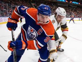 Vegas Golden Knights' Mark Stone (61) and Edmonton Oilers' Connor McDavid (97) battle for the puck during first period NHL action in Edmonton on Saturday, November 19, 2022.THE CANADIAN PRESS/Jason Franson