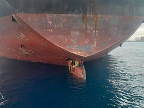 In this photo released by Spain's Maritime Safety and Rescue Society on Tuesday Nov. 29, 2022, three men are photographed on an oil tanker anchored in the port of the Canary Islands, Spain. Spain's Maritime Rescue Service says it has rescued three stowaways traveling on a ship's rudder in the Canary Islands after the vessel sailed there from Nigeria. The men were found on the Alithini II oil tanker at the Las Palmas port. (Salvamento Maritimo via AP)