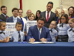 FILE - Florida Gov. Ron DeSantis signs the Parental Rights in Education bill at Classical Preparatory school, on March 28, 2022, in Shady Hills, Fla. The Walt Disney Company announced late Sunday, Nov. 20, 2022, that former CEO Bob Iger will return to head the company for two years in a move that stunned the entertainment industry. Disney said in a statement that Bob Chapek, who succeeded Iger in 2020, had stepped down from the position. Chapek faced blowback early this year for not using Disney's vast influence in Florida to quash the Republican bill that would prevent teachers from instructing early grades on LGBTQ issues.