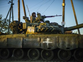 Ukrainian servicemen drive a tank as they cross Oskil village, Ukraine, Thursday, Oct. 6, 2022.