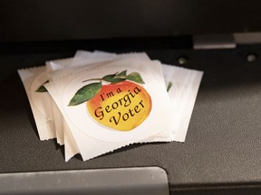 A stack of stickers sits atop the ballot scanner during the mid-term election Tuesday, Nov. 8, 2022 at Lawrenceville Road United Methodist Church in Tucker, Ga.