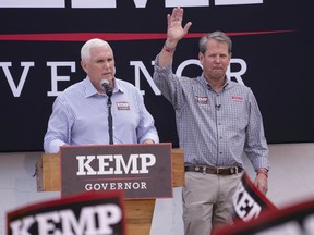 Republican Gov. Brian Kemp, right, reacts as former Vice President Mike Pence speaks during a campaign rally for Kemp's reelection bid, Tuesday, Nov. 1, 2022 in Cumming, Ga.
