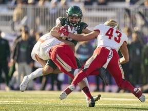 Jordin Rusnack of the Saskatchewan Huskies is tackled by Laval's Francis Bouchard(1) and Charles Alexandre Jacques (43) during the U Sports Vanier Cup in London, Ont., Saturday, Nov. 26, 2022.
