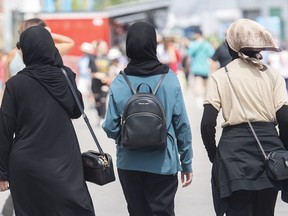 Women wear hijabs as they walk in the Old Port in Montreal on Thursday, August 11, 2022.