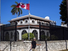 A man walks beside Canada's embassy in Havana, Cuba, Tuesday, April 17, 2018. Former Supreme Court justice Thomas Cromwell will mediate claims against the federal government from nine family members of Canadian diplomats who suffered unexplained ailments in Cuba.