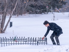 Prime Minister Justin Trudeau lays tobacco in front of a grave of one of the victims of a mass stabbing at James Smith Cree Nation, Sask., on Monday, Nov. 28, 2022.