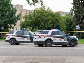 Two police vehicles are parked at College Drive near the University of Saskatchewan campus in Saskatoon, Sask., on Monday, July 18, 2022. Police say remains found near a Saskatchewan village are of a missing woman whose disappearance more than two years ago is considered a homicide.