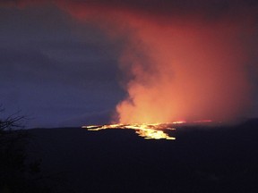 Lava pours out of the summit crater of Mauna Loa about 6:35 a.m. Monday, Nov. 28, 2022, as seen from Gilbert Kahele Recreation Area on Maunakea, Hawaii. Mauna Loa, the world's largest active volcano, began spewing ash and debris from its summit, prompting civil defense officials to warn residents on Monday to prepare in case the eruption causes lava to flow toward communities.