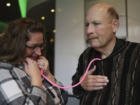 Amber Morgan, from South Bend, Ind., listens to the heartbeat of Tom Johnson, from Kankakee, at Travelodge by Wyndham Downtown Chicago, on Saturday, Nov. 19, 2022, in Chicago. Morgan and Johnson met for the first time Saturday, four years after he received a heart transplanted from the body of Morgan's daughter, Andreona Williams, who was 20 when she died from asthma complications. "It's almost like I got to hug my daughter again," Morgan said.