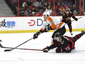 Ottawa Senators defenceman Thomas Chabot (72) falls on the ice as he knocks the puck away from Philadelphia Flyers right wing Travis Konecny (11) to prevent him from breaking away during first period NHL hockey action in Ottawa, on Saturday, Nov. 5, 2022.