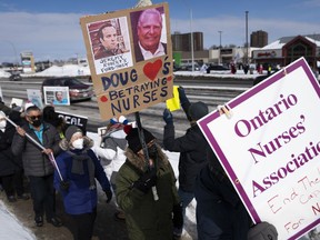 Nurses and their supporters protest Premier Doug Ford and Ontario's Bill 124 on the sidewalk in front of the constituency office of PC MPP for Ottawa West-Nepean Jeremy Roberts in Ottawa, on Friday, March 4, 2022.&nbsp;An Ontario court has struck down a bill that limited wages for public sector workers.&nbsp;&nbsp;THE CANADIAN PRESS/Justin Tang