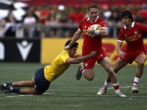 Canada's Cooper Coats (15) tries to evade the tackle of Spain's Alejandro Alonso Munoz (13) during the second half of men's 15s international rugby action in Ottawa, on Sunday, July 10, 2022. Canada scored 24 second-half points en route to a 37-25 win over the Netherlands on Saturday in an international rugby test match.THE CANADIAN PRESS/Justin Tang
