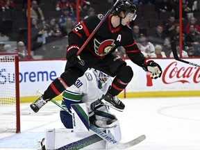 Vancouver Canucks goaltender Spencer Martin (30) makes a glove save as Ottawa Senators defenceman Thomas Chabot (72) leaps to try and clear a path for the puck, during second period NHL hockey action in Ottawa, on Tuesday, Nov. 8, 2022.