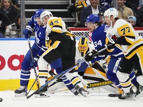 Pittsburgh Penguins' goaltender Casey DeSmith (1) looks for the puck as Toronto Maple Leafs' John Tavares (91), battles with Penguins' Jan Rutta (44) and Maple Leafs' Auston Matthews (34) battles with Penguins' Jeff Carter (77) during first period NHL hockey action in Toronto, Friday, Nov. 11, 2022.