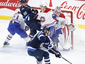 Winnipeg Jets' Pierre-Luc Dubois (80) gets tangled up with Montreal Canadiens' Kaiden Guhle (21) and Jake Evans (71) in front of goaltender Sam Montembeault (35) as Jets' Kyle Connor (81) tries to get a shot away during second period NHL action in Winnipeg, Thursday, November 3, 2022.