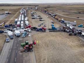 Anti-mandate demonstrators gather as a truck convoy blocks the highway the busy U.S. border crossing in Coutts, Alta., Monday, Jan. 31, 2022.THE CANADIAN PRESS/Jeff McIntosh