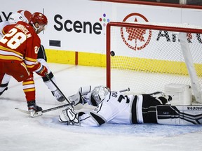 Los Angeles Kings goalie Jonathan Quick, right, is scored on by Calgary Flames forward Elias Lindholm during second period NHL hockey action in Calgary, Monday, Nov. 14, 2022.THE CANADIAN PRESS/Jeff McIntosh