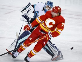 Seattle Kraken goalie Joey Daccord, left, comes out the crease to play the puck as Calgary Flames forward Tyler Toffoli crashes into him during third period NHL hockey action in Calgary, Alta., Tuesday, Nov. 1, 2022.