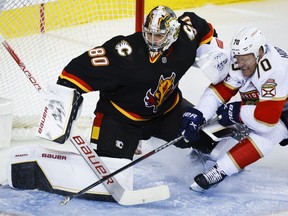 Florida Panthers forward Patric Hornqvist, right, crashes into Calgary Flames goalie Dan Vladar during second period NHL hockey action in Calgary, Tuesday, Nov. 29, 2022.THE CANADIAN PRESS/Jeff McIntosh