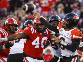 BC Lions quarterback Vernon Adams, right, throws the ball as Calgary Stampeders defensive lineman Shawn Lemon closes in during second half CFL football action in Calgary, Saturday, Sept. 17, 2022.THE CANADIAN PRESS/Jeff McIntosh