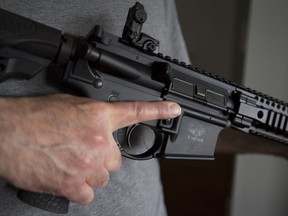 A restricted gun licence holder holds a AR-15 at his home in Langley, B.C. May 1, 2020.