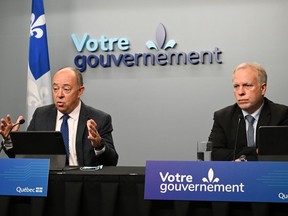 Quebec Health Minister Christian Dube speaks at a news conference on the situation concerning COVID-19, RSV and influenza, Wednesday, November 16, 2022 in Quebec City. Luc Boileau, Quebec director of National Public Health, right, looks on.