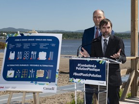 Federal Minister of Environment and Climate Change Steven Guilbeault, announces the ban of single-use plastics, at a beach, on Monday, June 20, 2022 in Quebec City. Federal Health Minister Jean-Yves Duclos, behind, looks on.